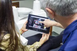 Dentist and patient reviewing an x-ray on a tablet