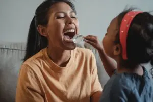daughter examing mothers mouth
