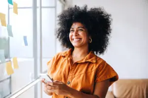 Happy businesswoman smiling holding iPhone