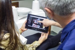 Dentist and patient reviewing an x-ray on a tablet