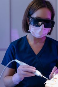Dentist wearing sunglasses examines a patient