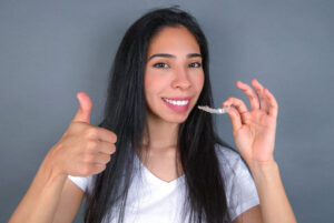 young woman with Invisalign aligner