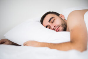 Man sleeping in bed on white pillow